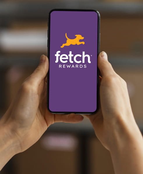 Delle mani che reggono uno smartphone con fetch rewards