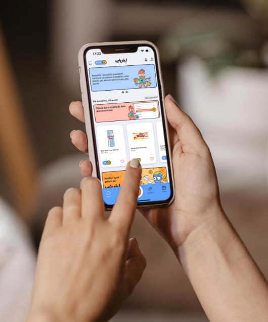Delle mani che reggono uno smartphone con l'app di Urkah! aperta